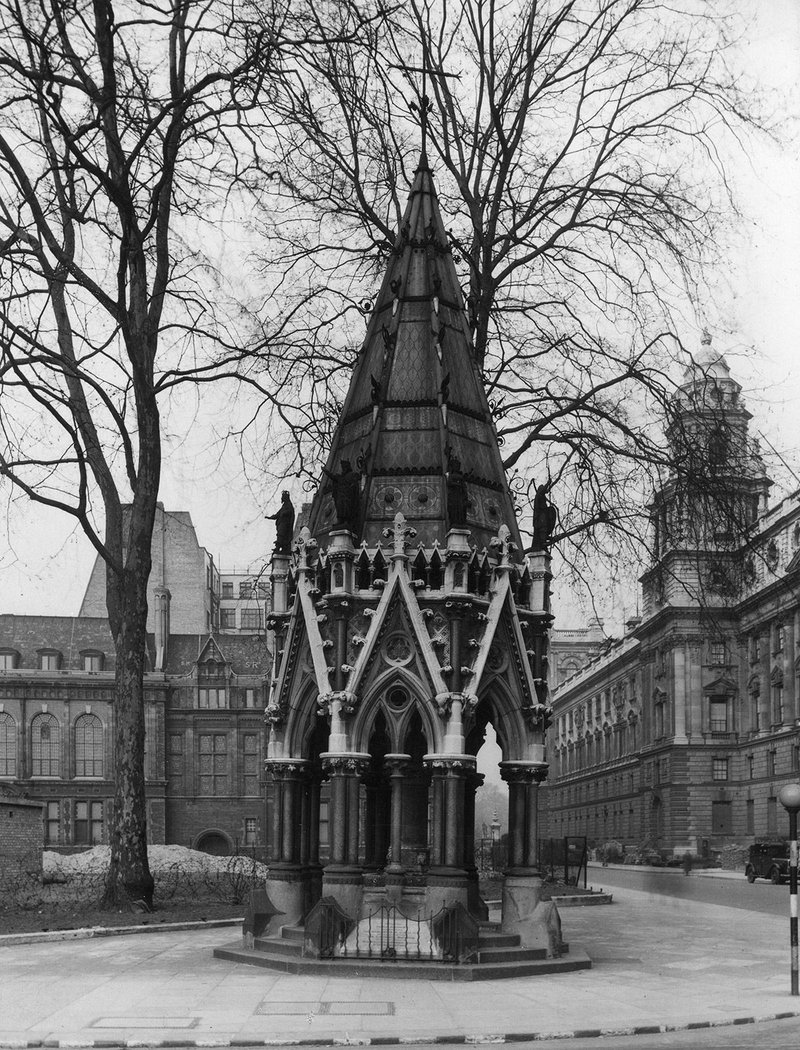 The public drinking fountain, built in Gothic style by Samuel Sanders Teulon (1812-1873)  was built to commemorate Sir T. Fowell Buxton,  a Member of Parliament, who with others campaigned for the emancipation of slaves in British colonies. Originally built in the north-west  corner of Parliament Square, it was moved in 1957 to its current position in Victoria Tower Gardens.