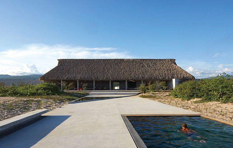 Casa Wabi viewed from the beach. It took 18 workers more than two months to weave 40,000 palm tree leaves to construct the roof.