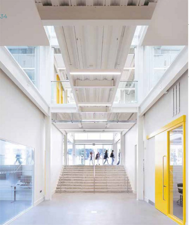 The main entrance, with staircase up to first floor. The white theme continues inside, with light permeating down from rooflight slots.