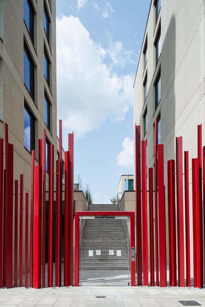 Access for residents takes you through red painted steel ‘flames’ via steps or lift to podium level.