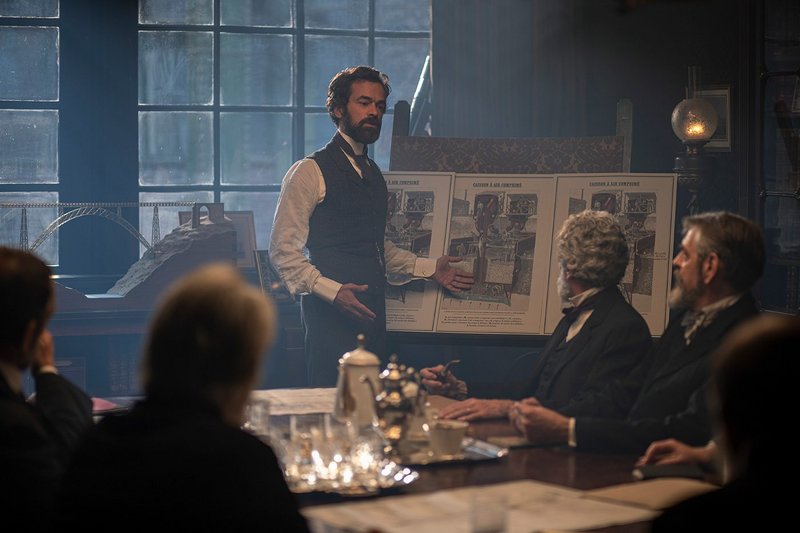 Gustave Eiffel (Romain Duris) presenting his conception of the Tower in the film Eiffel, directed by Martin Bourboulon.