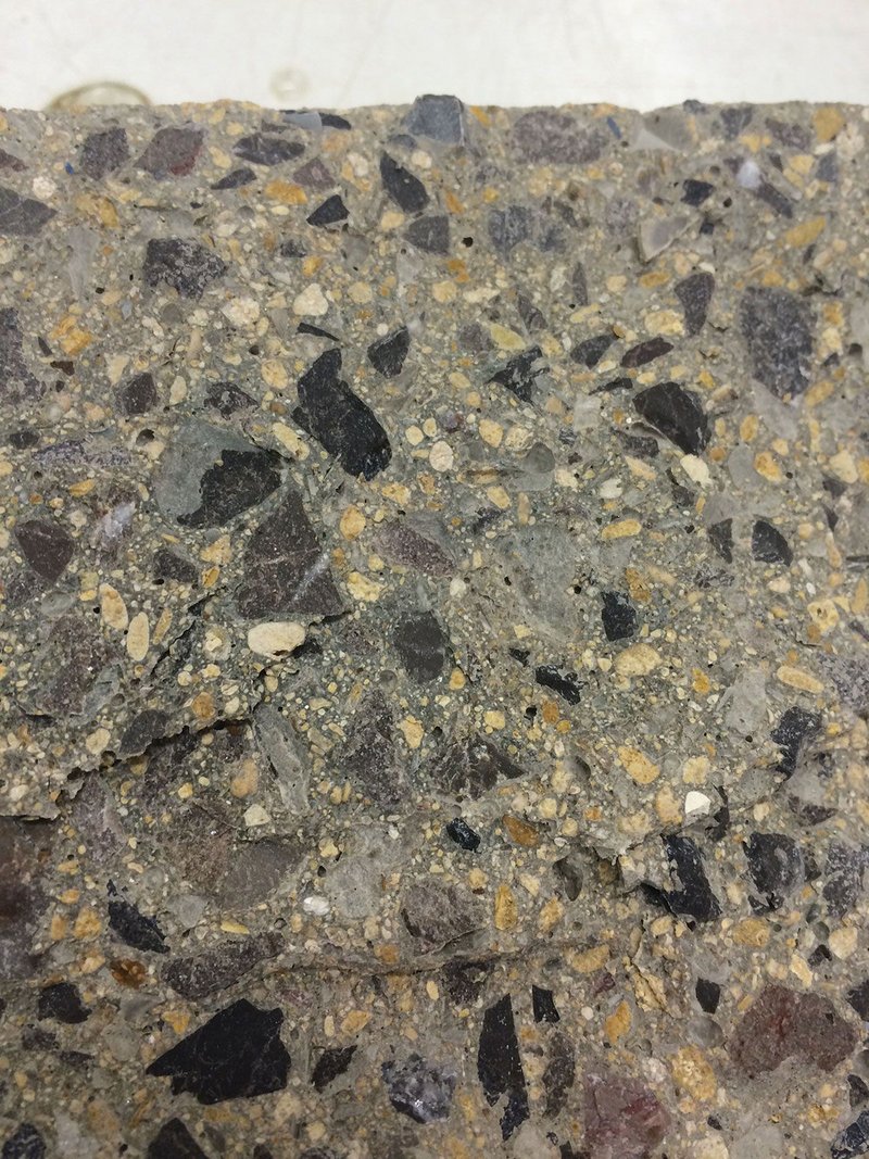 Close-up view of concrete with plastic particles replacing some of the sand.