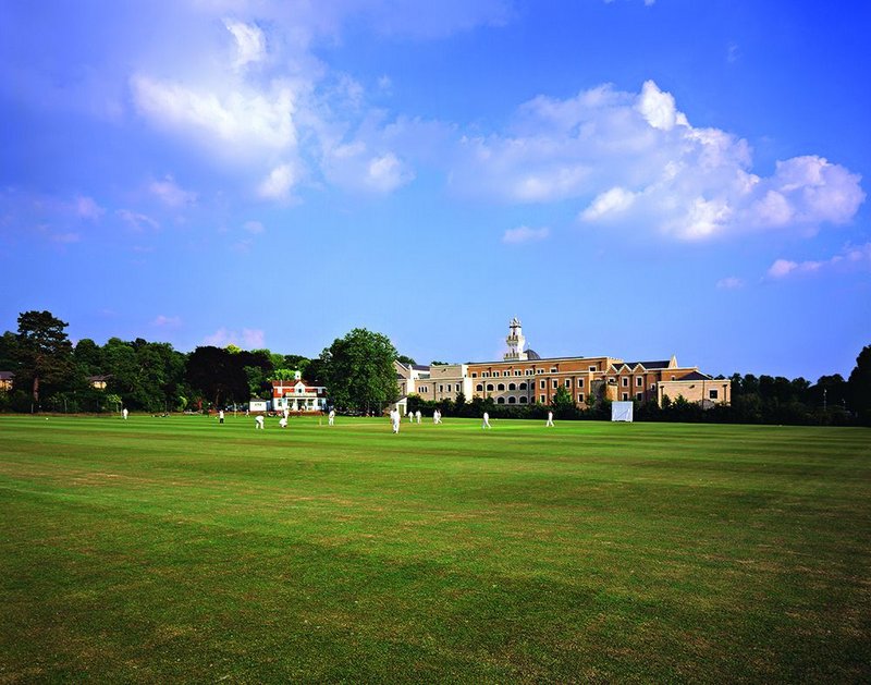 The minaret and dome of the Oxford Centre for Islamic Studies rising from the green pitch of Magdalen College’s grounds.