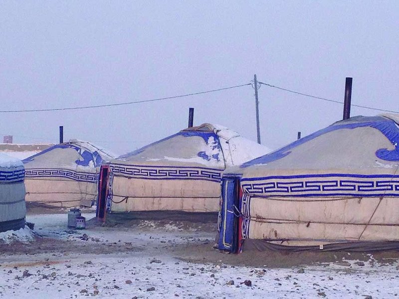 Gers in the snow, the chimneys from their stoves protruding through the roofs.