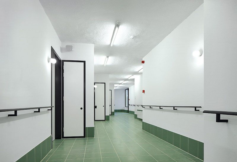 The staggered elevation is echoed inside, giving a partially sheltered entrance area to every room along the corridor. High contrast floors and frames help orientate the partially sighted. Seats at the end of corridors allow residents to enjoy views out.
