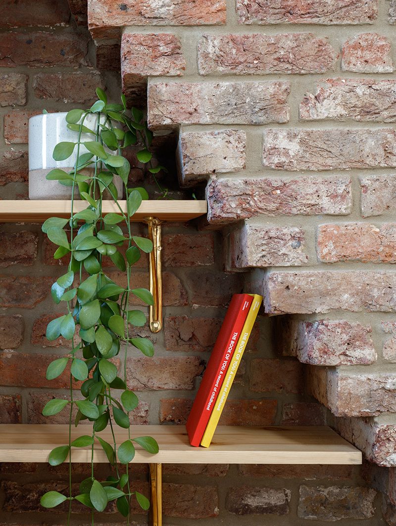 Bedroom detail of the wood shelving within the original stepping brickwork of the chimney.