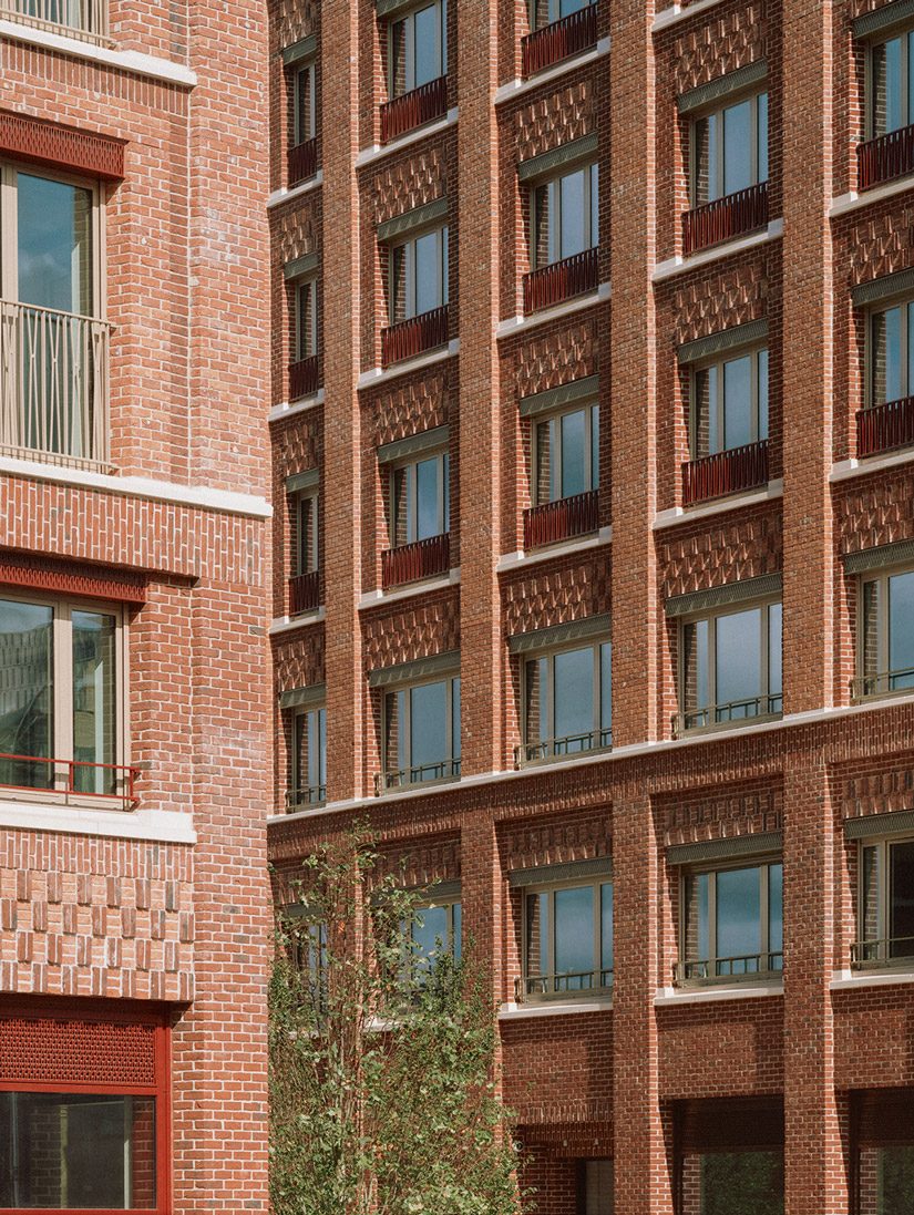 Three colours of brick and careful compositions detail facades.